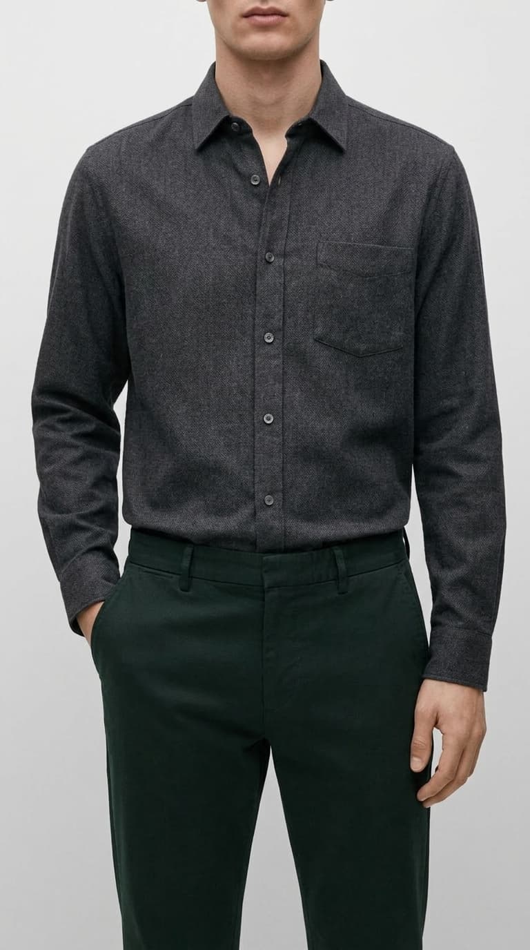 Man wearing a dark gray textured long-sleeve button-down shirt with a chest pocket and dark green trousers.