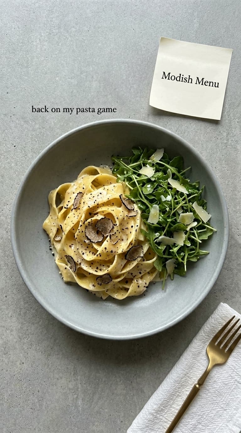 A bowl of fettuccine with truffle and a side of arugula salad.
