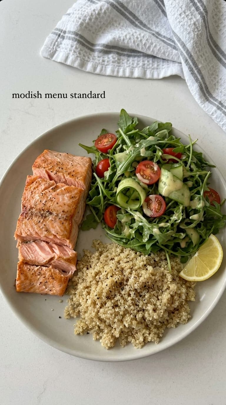 A plate of grilled salmon, quinoa, and arugula salad with tomatoes and cucumber.
